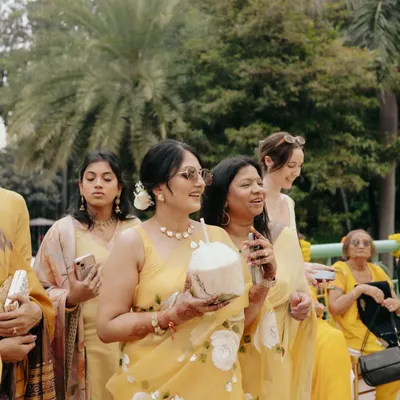 Guests enjoying the personalized coconut bar at a Haldi ceremony. It's a refreshing and thoughtful touch that adds a tropical, fun vibe to a summer wedding.