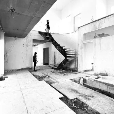 The raw form of a helical staircase in a private residence in Tiruppur. Designed to be a sculptural element in the main hall, the 'missing shaft' creates a sense of lightness and dynamism, with a skylight above illuminating the entire structure.