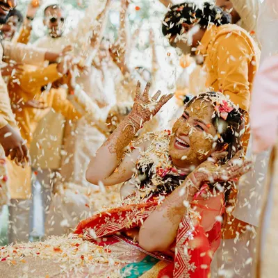 An explosion of joy and flower petals! We love capturing the peak moments of a Haldi ceremony, where the bride is showered with love and blessings in the most vibrant way.