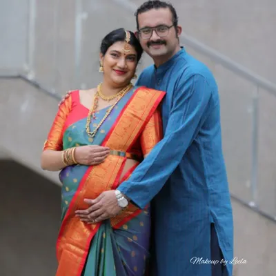 A heartwarming photo of a couple at their baby shower. The mother-to-be is glowing with a soft makeup look that highlights her happiness.