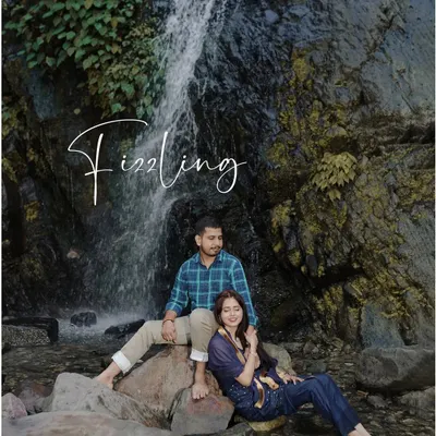 A serene pre-wedding portrait of a couple sitting by a cascading waterfall, perfectly blending romance with the beauty of nature.