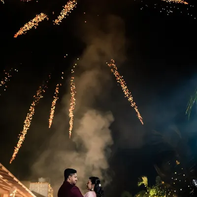 A magical reception photo of the couple under a sky full of fireworks. We specialize in capturing these spectacular, once-in-a-lifetime moments.