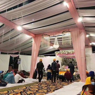 A wide view of the Anand Karaj setup, showing the seating arrangement for the guests and the beautifully decorated space for the Guru Granth Sahib.