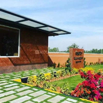 The entrance to the Sarjapura road residential layout features a modern building complemented by our landscape design, including checkerboard pathways and colorful bougainvillea.