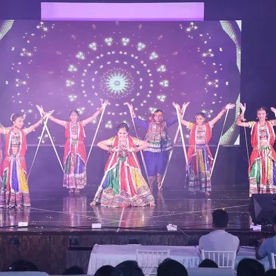 A beautiful formation from one of our stage Garba performances. The dancers use dandiya sticks to create a symmetrical and visually striking pattern, all while wearing colorful traditional attire.