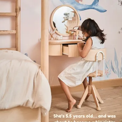 We decided to redo my daughter's wallpaper to prepare her for becoming a big sister. This is her at her new dresser, a space designed just for her.