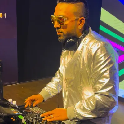 Focused on the mix during a corporate gig. I'm using the Pioneer controller to line up the next track, ensuring a seamless flow of music throughout the night.