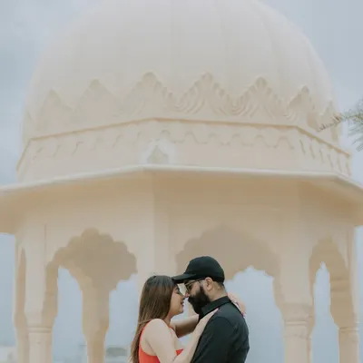 An intimate moment shared under the dome of a beautiful palace structure, creating a classic and romantic silhouette.