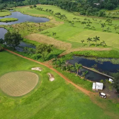An expansive aerial view of our 9-hole course, showing the layout of the fairways, sand bunkers, and multiple water bodies that make for a challenging and visually impressive round of golf.