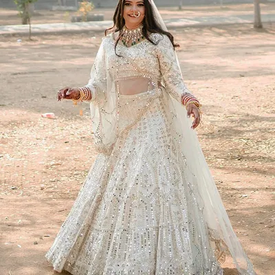 She dreamed of an ivory lehenga with full mirror and gotta pati work, and we brought it to life. This outfit is for the bride who wants to shine with timeless elegance on her wedding day.