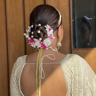 This stunning bridal bun combines fresh hydrangeas and delicate pearls for a look that is both classic and unique. It's a perfect choice for a bride wearing an all-white or pastel lehenga.