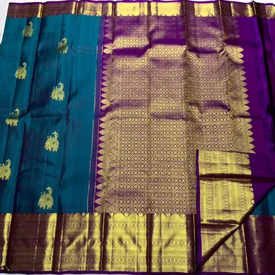 A closer look at the rich texture of the handwoven Kanchipuram silk saree, showcasing the pure 2g zari work on the border and pallu.