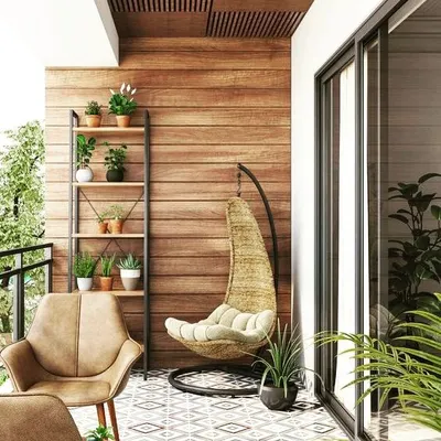 This cozy balcony is designed for relaxation, featuring a comfortable swing chair, a modern armchair, and a plant ladder to display greenery. The combination of a wood-paneled wall and patterned floor tiles adds warmth and character.