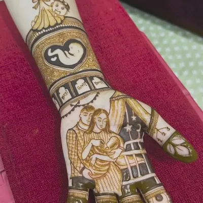 A heartwarming baby shower mehandi that tells a family's story. This design includes a portrait of the couple with their newborn, a fetus design in a heart, and the year of birth.
