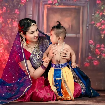 The timeless love of Yashoda and her little Krishna. We created this beautiful themed portrait to celebrate a mother's bond, using traditional attire and a rich, floral backdrop.