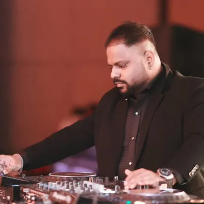 Focused on the mix during a lively wedding event. Dressed for the occasion, I'm at my Pioneer console, ensuring every track flows seamlessly to keep the celebration going.