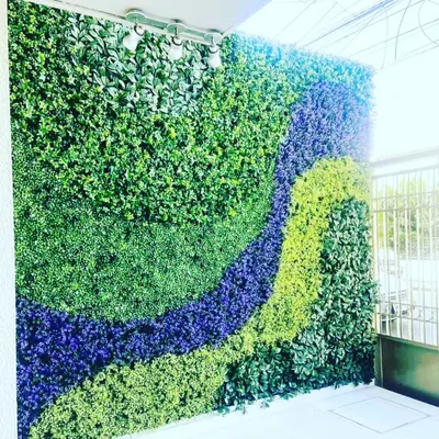 This is a large outdoor green wall I installed, using different shades and textures of artificial foliage to create a wave-like pattern. This custom design work is perfect for balconies, terraces, or building exteriors.