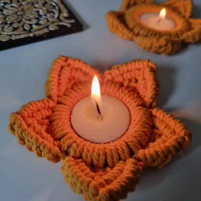 Light up your home with my macrame tealight holders. Shaped like a flower, these orange holders cast a warm, inviting glow, perfect for Diwali or any festive occasion.