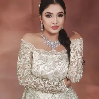 This elegant off-the-shoulder gown is paired with a stunning, multi-layered American Diamond necklace and matching earrings. This is a perfect look for a glamorous reception or engagement party.