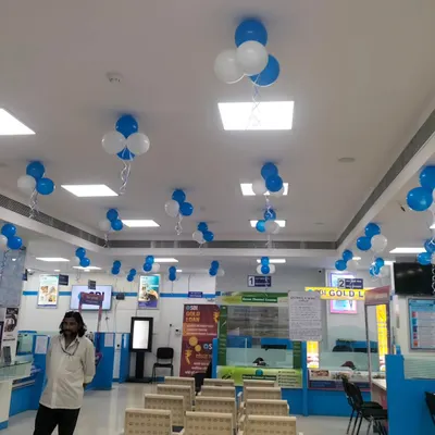 Simple and effective blue and white balloon clusters hanging from the ceiling of a corporate office. This is an easy way to decorate a large office floor for a company-wide celebration.