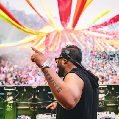 Pointing to the sky as the confetti falls at a massive Holi event. My goal is to command the stage and direct the energy of thousands, making sure every single person is part of the celebration.