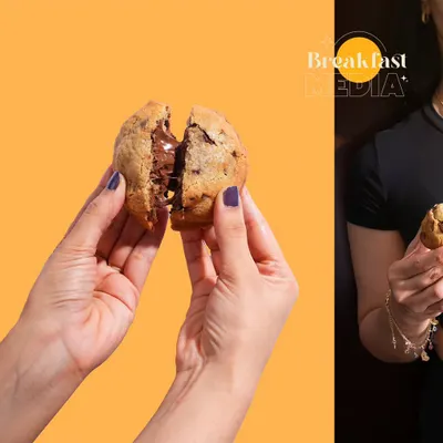 This shot is all about the "break-apart" moment, revealing the gooey, melted chocolate inside the cookie. Using a bold, solid color background makes the product the hero and creates a visually striking image for social media.