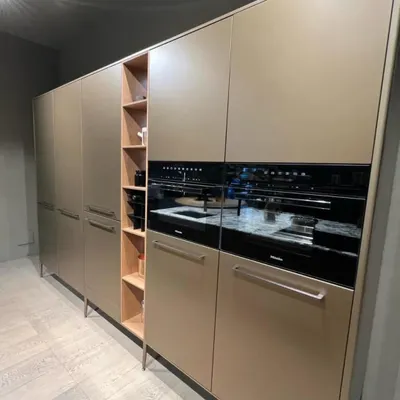 This tall unit, on display in our showroom, showcases practical functionality with clean lines. It features integrated appliances and open shelving for display, demonstrating how we combine storage and utility in a sleek, modern design.