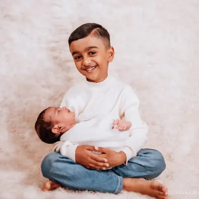 The proudest big brother. His joyful smile as he holds his new sibling says everything. These are the moments that become treasured family memories.