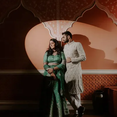 In the studio, we play with light and shadow to create dramatic, artistic portraits. This image uses a single spotlight to highlight the couple against a richly textured, Rajasthani-inspired backdrop, showcasing our versatility in a controlled creative environment.