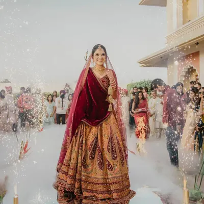 A stunning bridal entry. The bride walks down an aisle filled with smoke and sparklers, creating a magical and dramatic moment that is all about her.