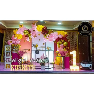 We love bringing big themes to life, like this butterfly-themed first birthday party. This grand setup includes a multi-colored balloon arch, decorative pedestals for the cake, light-up letters for the baby's name, and a large marquee number '1'.