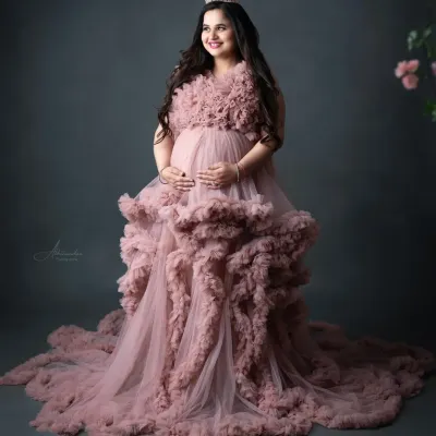 A true fairytale moment. This mom-to-be looks absolutely radiant in our ruffled pink cloud gown, complete with a crown for that perfect regal touch.