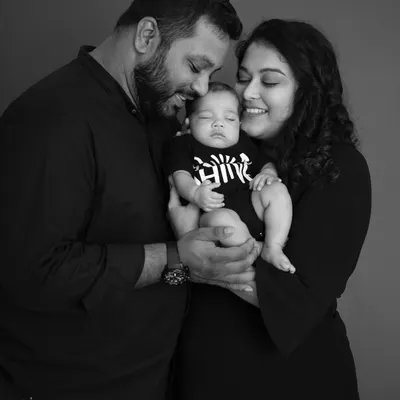 A quiet, intimate moment between new parents and their sleeping baby. This black and white newborn portrait focuses on their loving expressions and the peacefulness of their new life together.