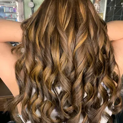 A stunning color correction. This client had a lot of previous dark color build-up, and we transformed it into this beautiful, sun-kissed look using a bleach and tone technique.