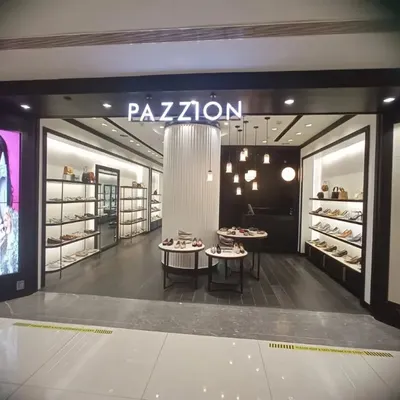 The storefront of the Pazzion luxury footwear store at DLF Avenue, Delhi. The design features a dark, sophisticated facade with a brightly lit interior to draw customers in, showcasing our ability to create inviting retail entrances.