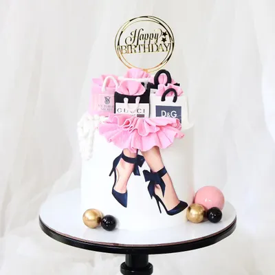 A super stylish cake for the shopaholic. This design features an edible print of fashionable legs, a pink fondant skirt, and is topped with handcrafted, miniature shopping bags from luxury brands like Gucci and D&G.