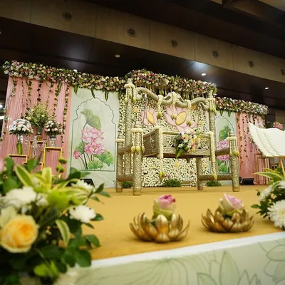 A wide view of our lotus-themed stage for a traditional cradle ceremony. The setup includes a beautifully decorated cradle, a floral wall with painted details, and coordinated props, creating a harmonious and elegant setting.