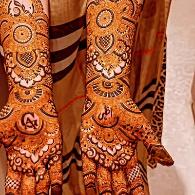 We offer detailed mehendi for family and guests that is just as beautiful as our bridal work. This design features intricate mandalas and personalized initials, perfect for any celebration.