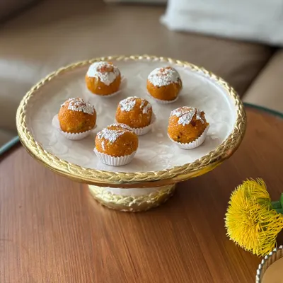 Our elegant cake stand with a detailed gold-finished base and an enamel top, shown here serving traditional Indian sweets. It’s designed to make every dessert presentation a moment of celebration.