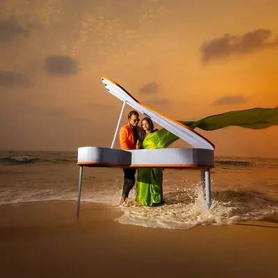 A grand piano on the beach at sunset. We believe in creating surreal and unforgettable concepts for your save the date or pre-wedding shoot, making your announcement truly stand out.