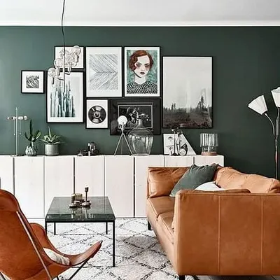 A deep forest green accent wall creates a moody and sophisticated atmosphere in this living room. We advise on how to balance such strong colours with lighter furniture and flooring.
