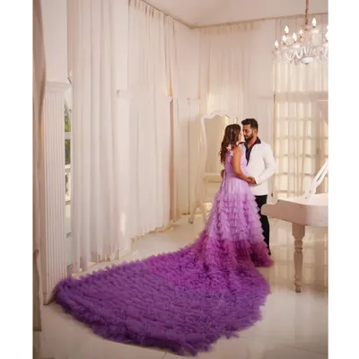 For a truly dramatic and memorable photoshoot, I offer show-stopping pieces like this. The groom-to-be wears a crisp white tuxedo jacket, creating a stunning contrast with her magnificent ruffled purple gown. This is how you create unforgettable pre-wedding memories.