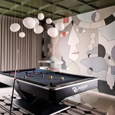 For this Bangalore home, we converted two bedrooms into the ultimate entertainment den. A professional pool table sits under a cloud of globe pendant lights, set against a dramatic, custom-designed mural wall.