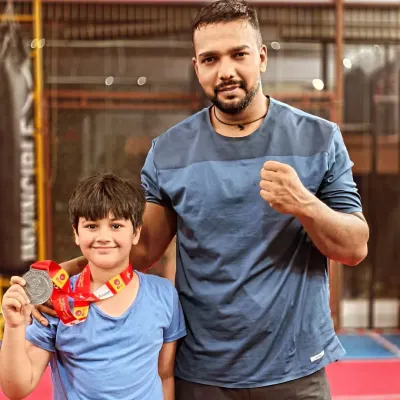 Posing with a young champion from my team. He earned his medal through hard work and dedication.