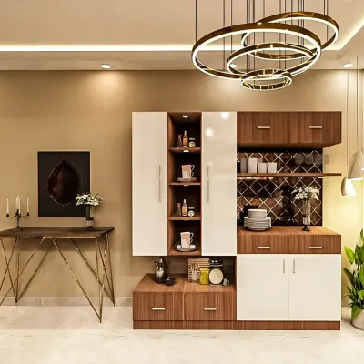 A stylish and modern crockery and bar unit in a white and wood finish. The design includes open shelves, a wine rack, and closed cabinets, all illuminated by a stunning circular chandelier.