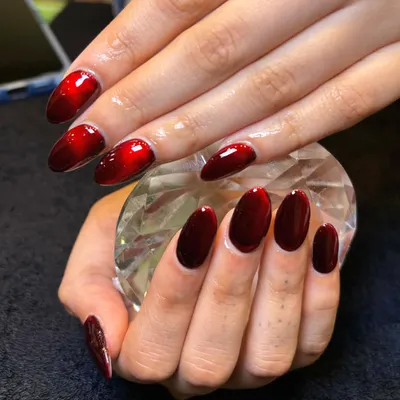 Subtle shimmer, bold statement. This is my red cat-eye nail art, which creates a stunning, dimensional effect. Here, the nails are held against a crystal to showcase their deep, velvety shine.