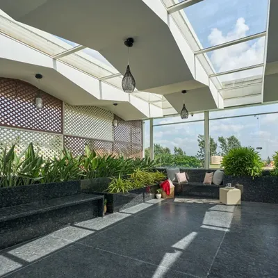 The terrace of the 'Wilasa' villa is a sun-filled atrium designed for relaxation. The skylight roof and extensive planters create a greenhouse effect, making it a perfect space for yoga or quiet contemplation.