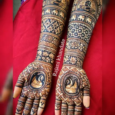 This bridal design is a symphony of traditional motifs. The palms feature elegant swans, while the arms are decorated with bands of peacocks, elephants, and intricate floral and geometric patterns.