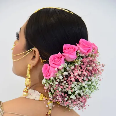 My popular floral bun, created with fresh pink roses and baby's breath. This hairstyle is a favorite among brides for its romantic and soft appearance, adding a beautiful, natural element to the overall look.