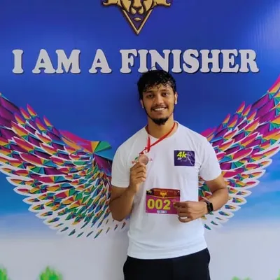 An athlete padrões with his finisher medal at the 4K Human Rights Day Run. We encourage our members to participate in events that promote fitness and a good cause.